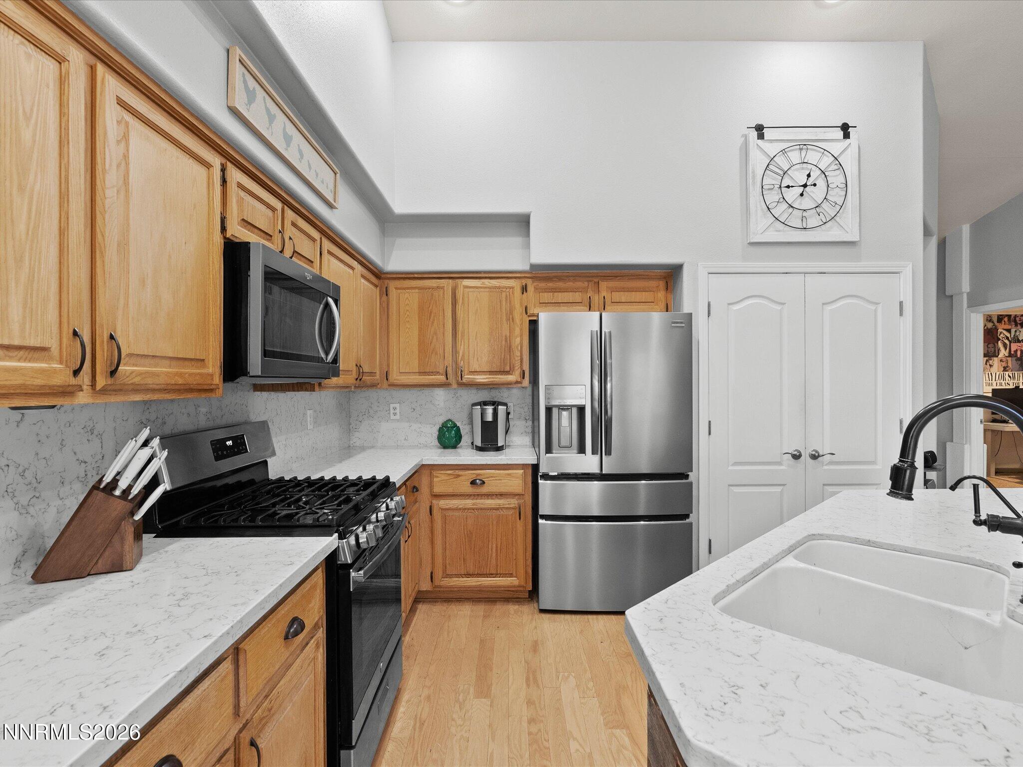 112 Alexander Court Fernley, NV 89408 - Photo 25 of 61 a kitchen with granite countertop a refrigerator stove and sink