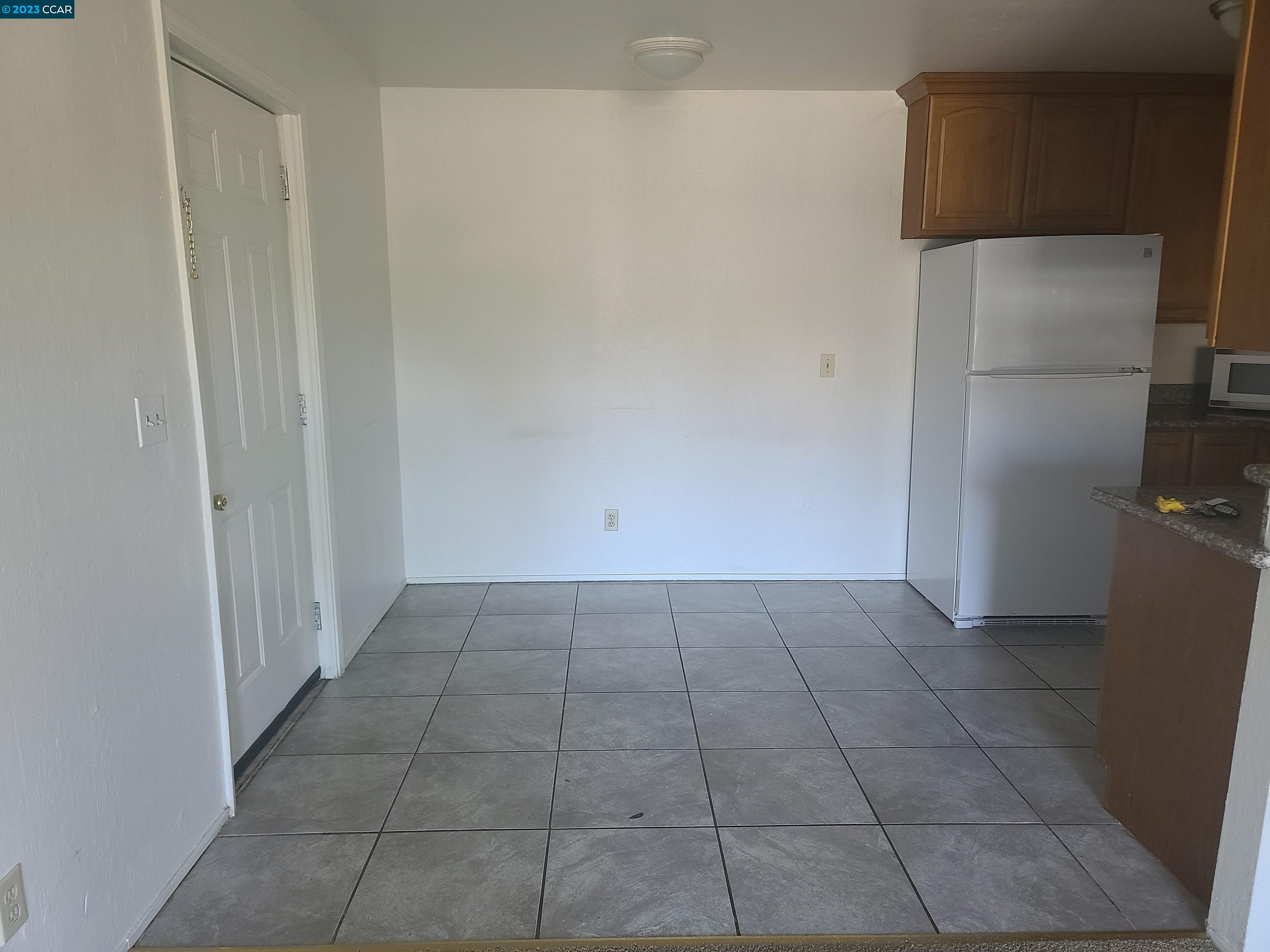 322 Vaqueros Avenue Rodeo, CA 94572 - Photo 3 of 6 a view of a refrigerator in kitchen and an empty room