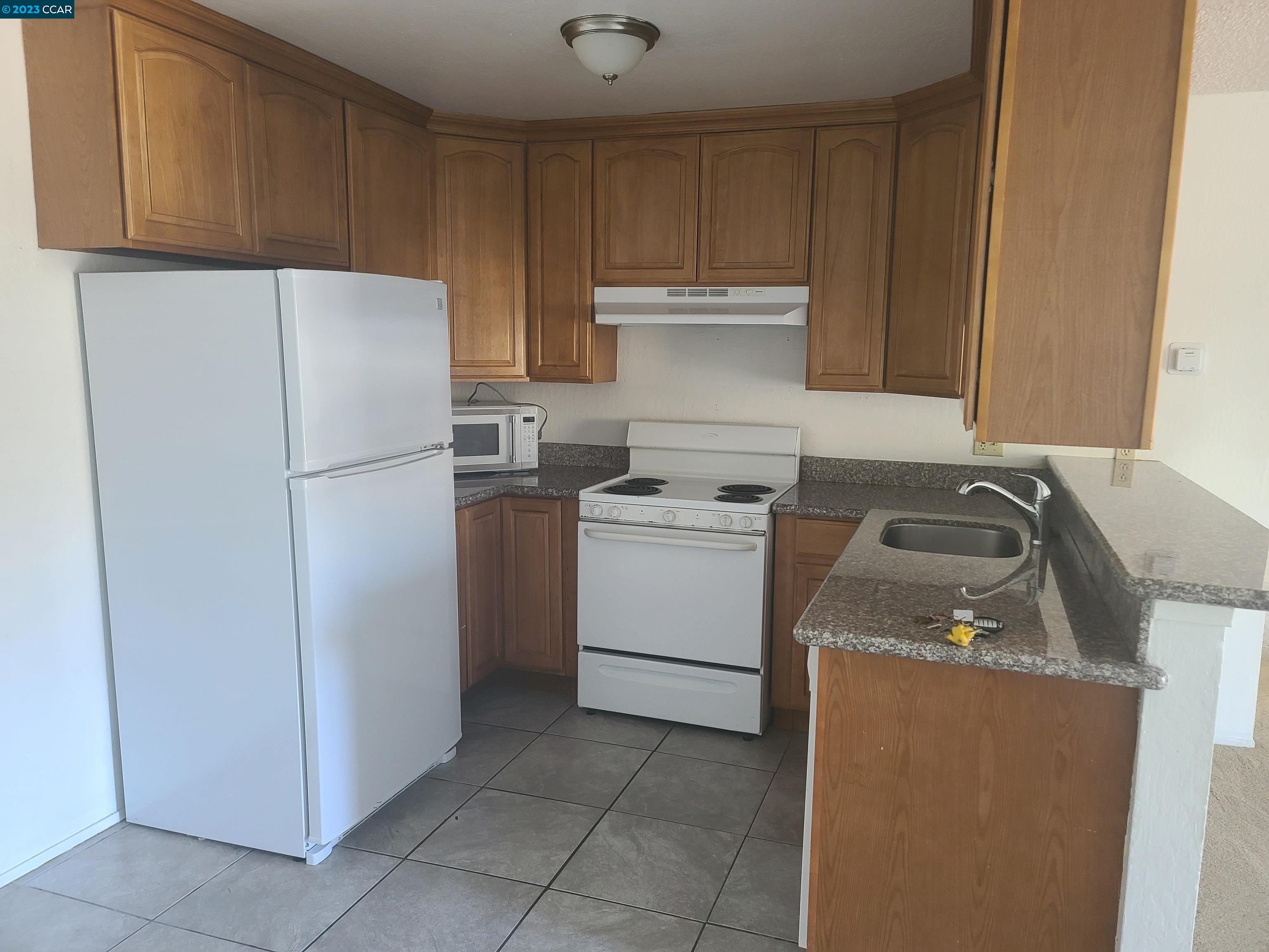 322 Vaqueros Avenue Rodeo, CA 94572 - Photo 4 of 6 a kitchen with a refrigerator sink stove and cabinets