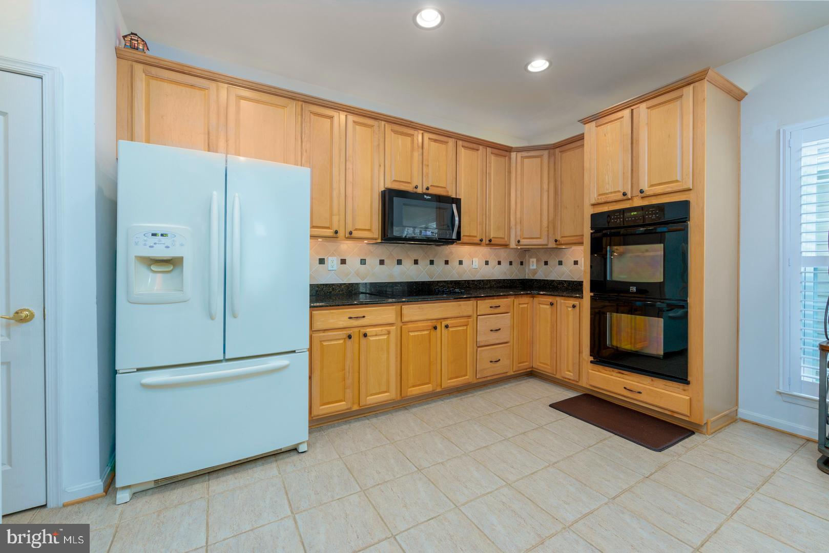 250 Concerto Avenue Centreville, MD 21617 - Photo 6 of 34 a kitchen with granite countertop a refrigerator and a stove top oven