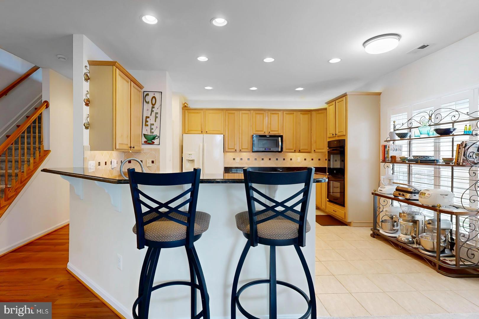 250 Concerto Avenue Centreville, MD 21617 - Photo 7 of 34 a kitchen with stainless steel appliances kitchen island granite countertop a table and chairs in it