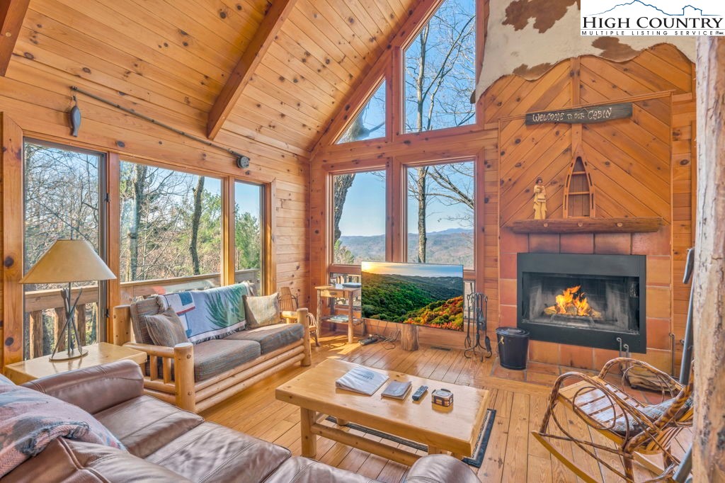 2095 Elk Ridge Road Ferguson, NC 28624 - Photo 14 of 34 a living room with furniture a fireplace and a floor to ceiling window