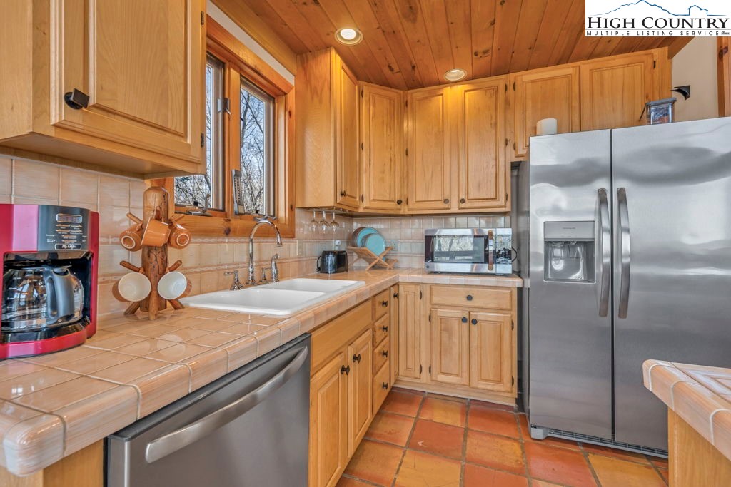2095 Elk Ridge Road Ferguson, NC 28624 - Photo 21 of 34 a kitchen with stainless steel appliances granite countertop a sink a refrigerator and a stove