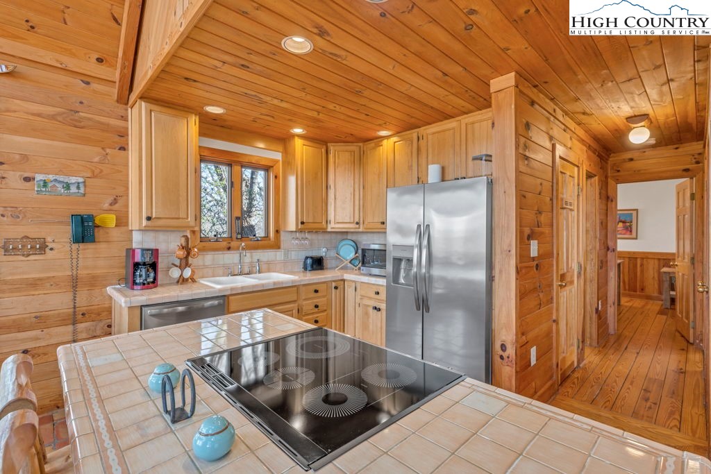 2095 Elk Ridge Road Ferguson, NC 28624 - Photo 22 of 34 a kitchen with stainless steel appliances granite countertop a refrigerator a sink a stove and white cabinets