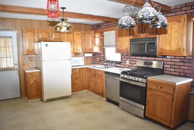 a kitchen with cabinets appliances and a chandelier