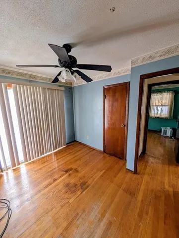 a view of a livingroom with wooden floor and a ceiling fan