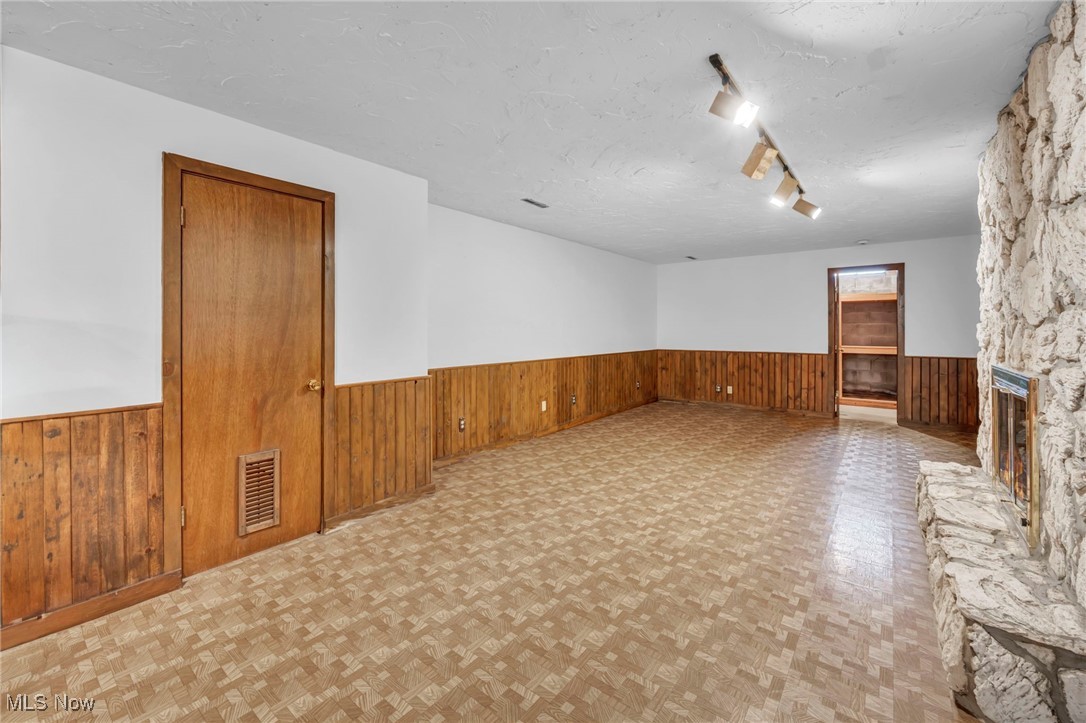 36350 Bainbridge Road Solon, OH 44139 - Photo 30 of 38 Unfurnished living room featuring light parquet floors, a textured ceiling, and a stone fireplace