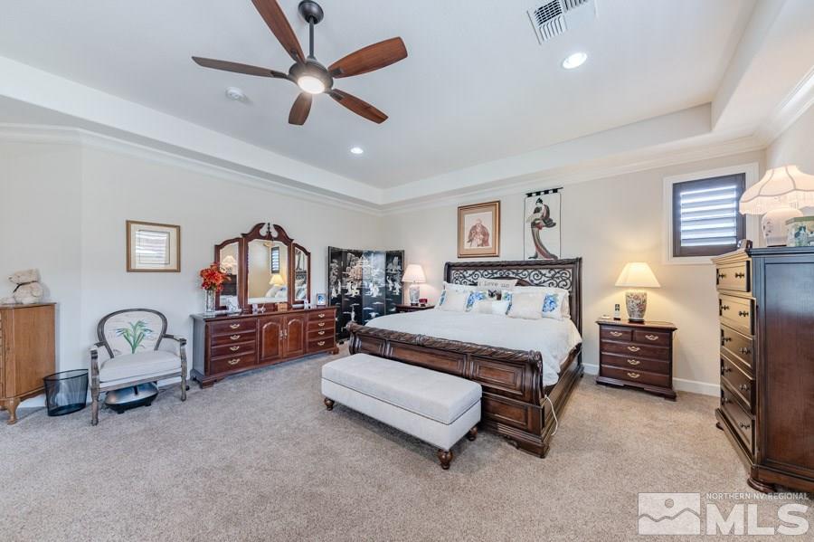 9850 Firefoot Lane Reno, NV 89521 - Photo 14 of 40 a spacious bedroom with a bed a couch and a chandelier