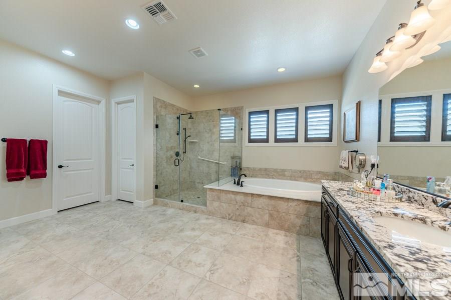 9850 Firefoot Lane Reno, NV 89521 - Photo 15 of 40 a spacious bathroom with a granite countertop tub sink shower and mirror