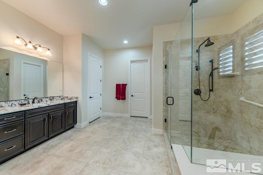 9850 Firefoot Lane Reno, NV 89521 - Photo 16 of 40 a spacious bathroom with a granite countertop sink mirror and shower