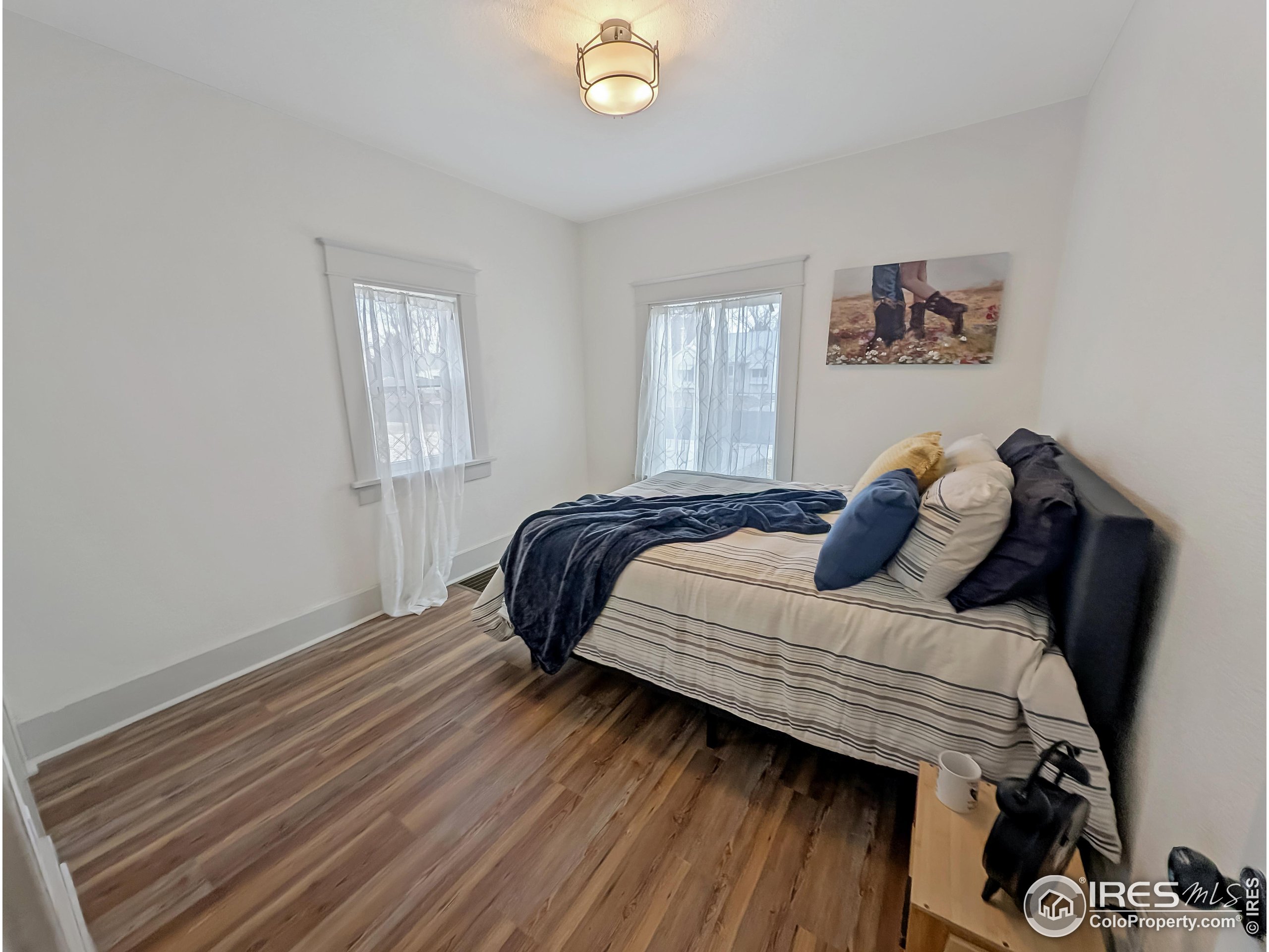 710 Carson Street Brush, CO 80723 - Photo 11 of 31 a bedroom with a bed and wooden floor