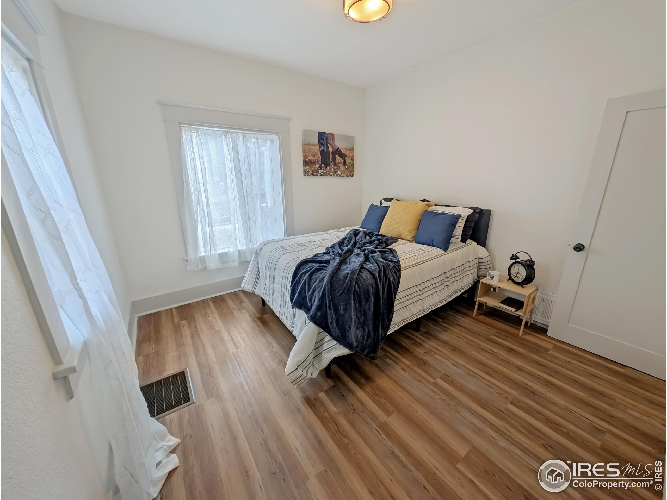 710 Carson Street Brush, CO 80723 - Photo 12 of 31 a bedroom with a bed and wooden floor