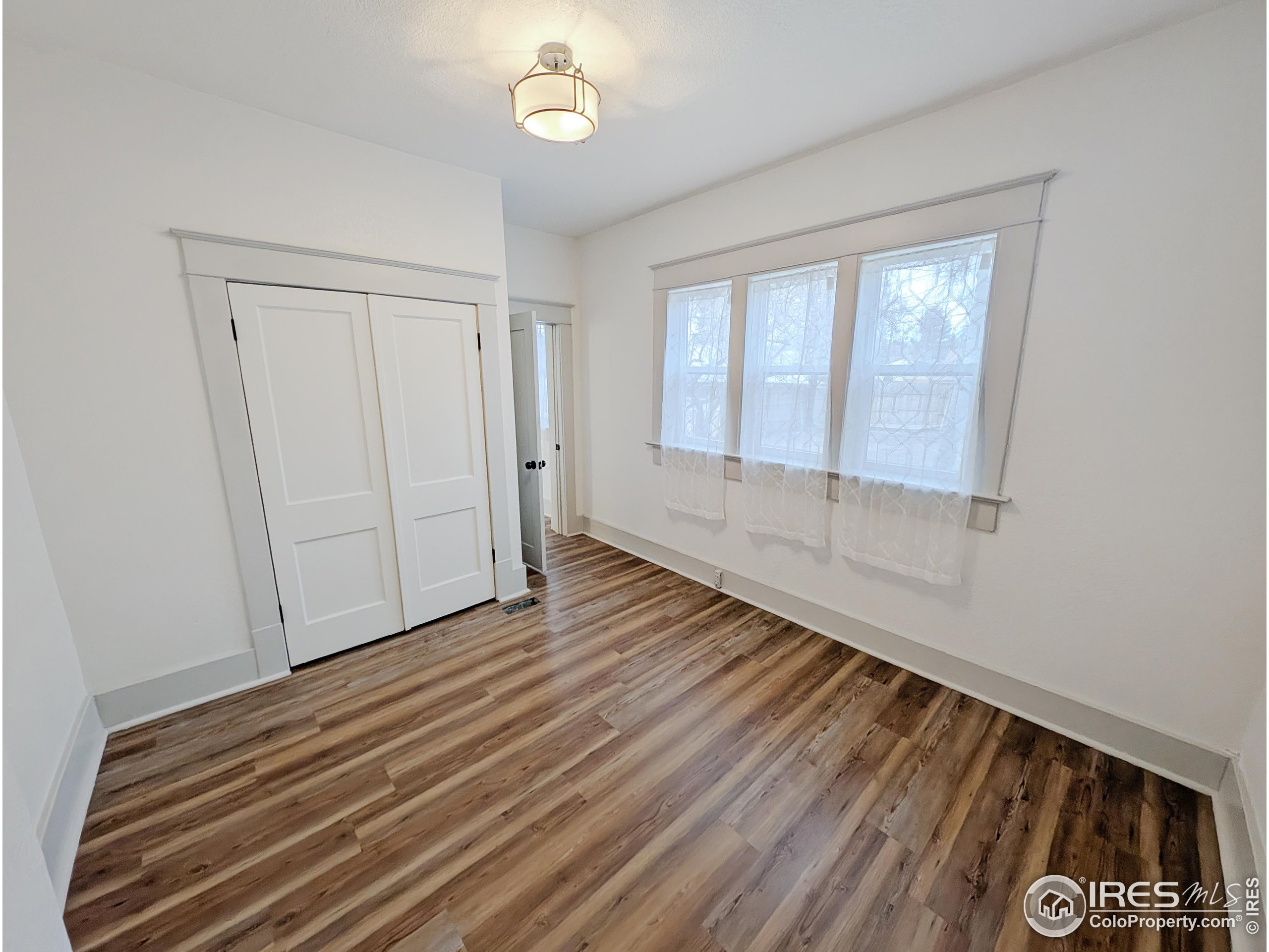 710 Carson Street Brush, CO 80723 - Photo 20 of 31 wooden floor in an empty room with a window