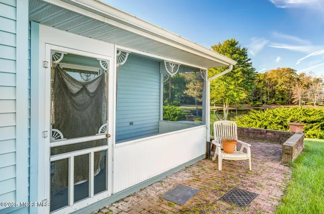a porch with a bench next to a yard