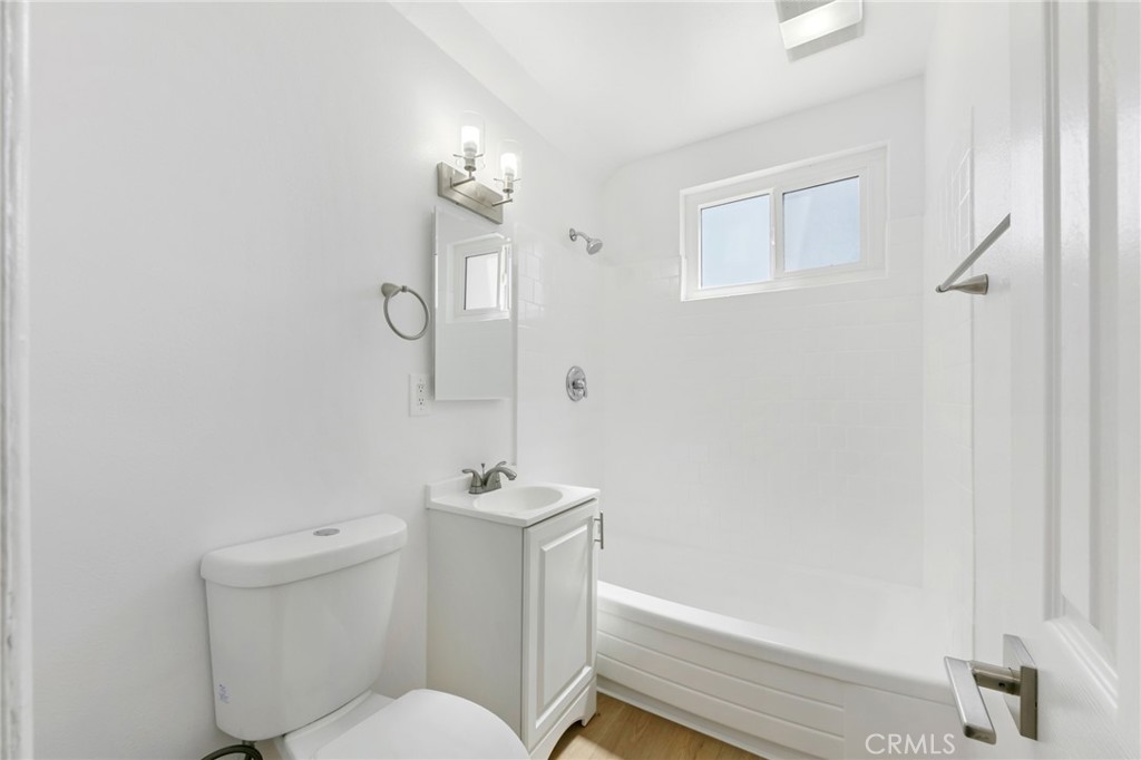 1242 Cedar Avenue Long Beach, CA 90813 - Photo 10 of 22 a white toilet sitting next to a bathroom sink and vanity