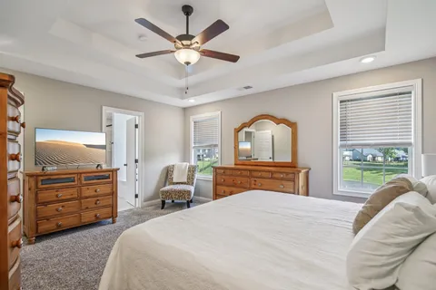a bedroom with a large bed and ceiling fan