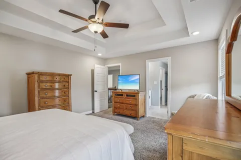 a bedroom with a bed and dresser with wooden floor