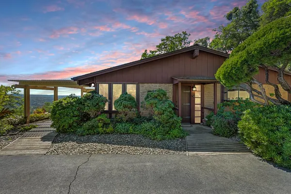 a yellow house with trees in front of it