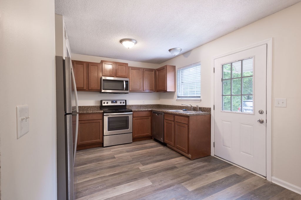 616 Castlegate Drive Nashville, TN 37217 - Photo 1 of 19 a kitchen with granite countertop a refrigerator and a stove top oven