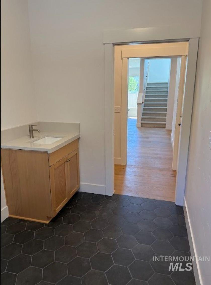 755 West Wrangler Street Meridian, ID 83646 - Photo 14 of 35 Hexagonal floor tiling with a light wood-finish vanity, light-toned countertop, and stainless steel faucet