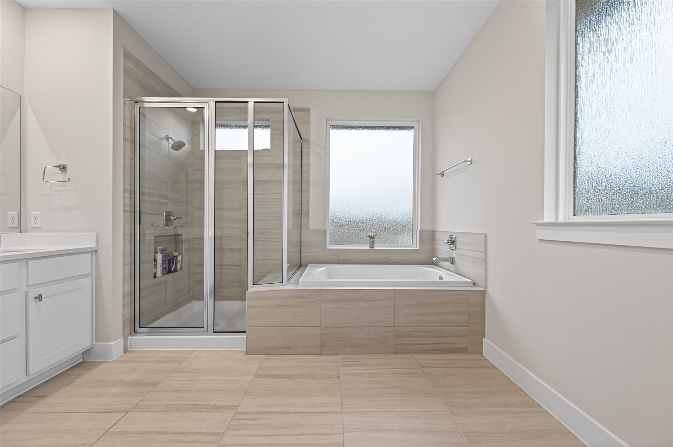 147 Nightshade Street Richmond, TX 77406 - Photo 36 of 47 The primary bathroom boasts a contemporary design with a glass-enclosed walk-in shower and a separate soaking tub. Dual vanities provide ample storage and counter space, creating a sophisticated and efficient morning routine