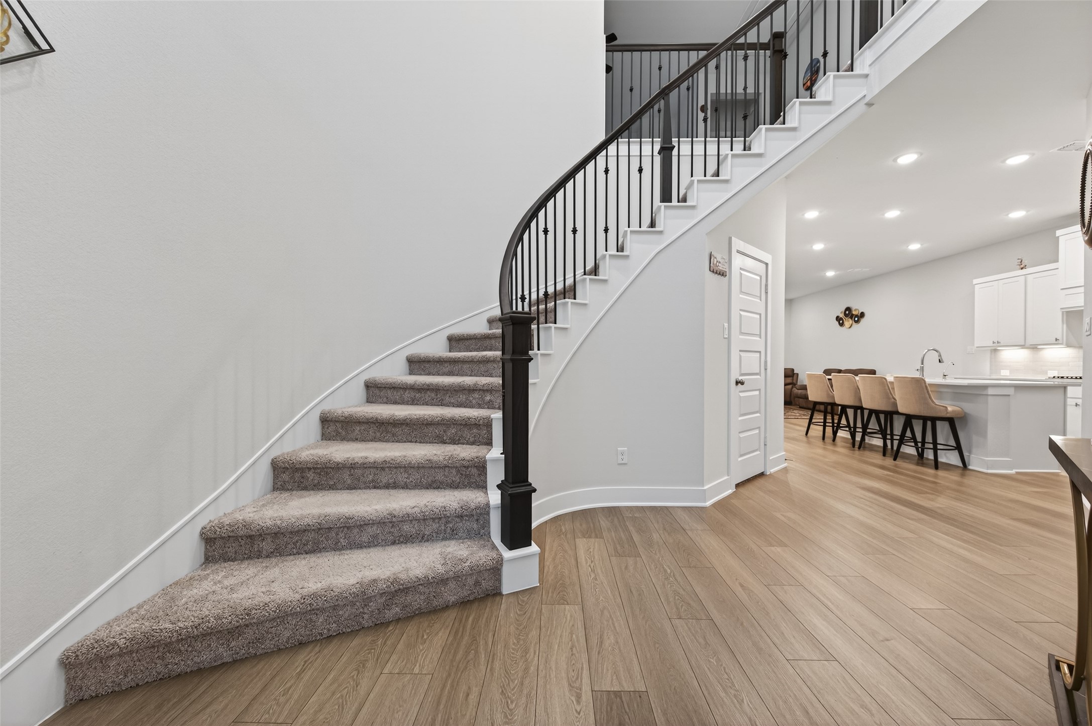 147 Nightshade Street Richmond, TX 77406 - Photo 8 of 47 A dramatic circular staircase with elegant wrought iron railings serves as the stunning centerpiece of the home, combining timeless craftsmanship with modern sophistication.