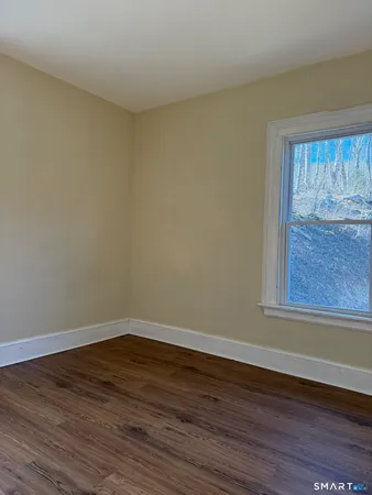a view of a small space with wooden floor and a window