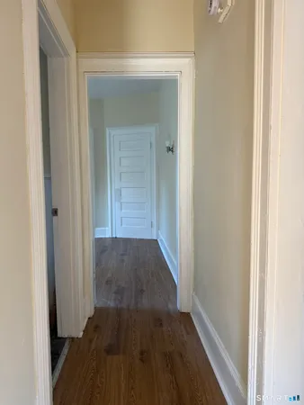 a view of a hallway with wooden floor
