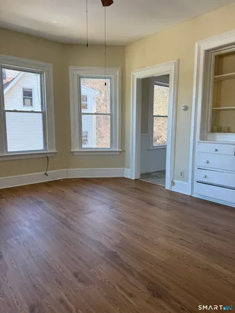 an empty room with wooden floor and windows