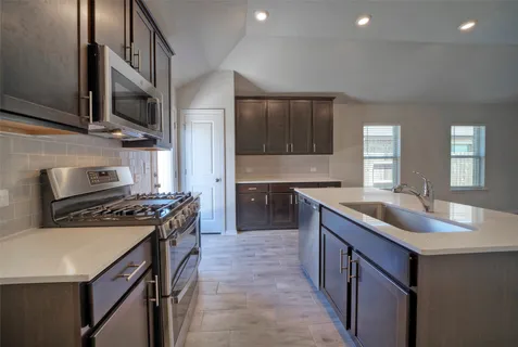 a kitchen with stainless steel appliances granite countertop a sink stove and refrigerator