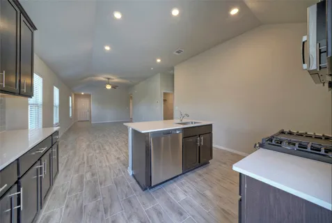 a kitchen with stove and wooden floor