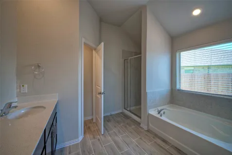 a bathroom with a tub sink and mirror