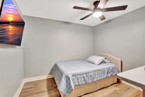 a bedroom with a bed and a ceiling fan