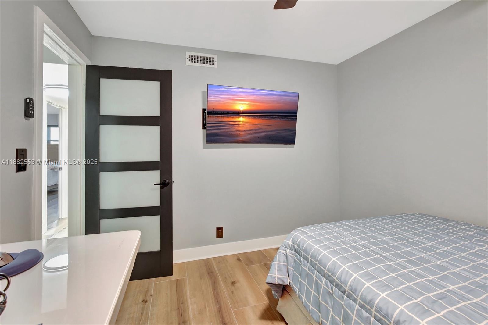 520 Orton Avenue, Unit 303 Fort Lauderdale, FL 33304 - Photo 16 of 20 a bedroom with a bed and a flat screen tv