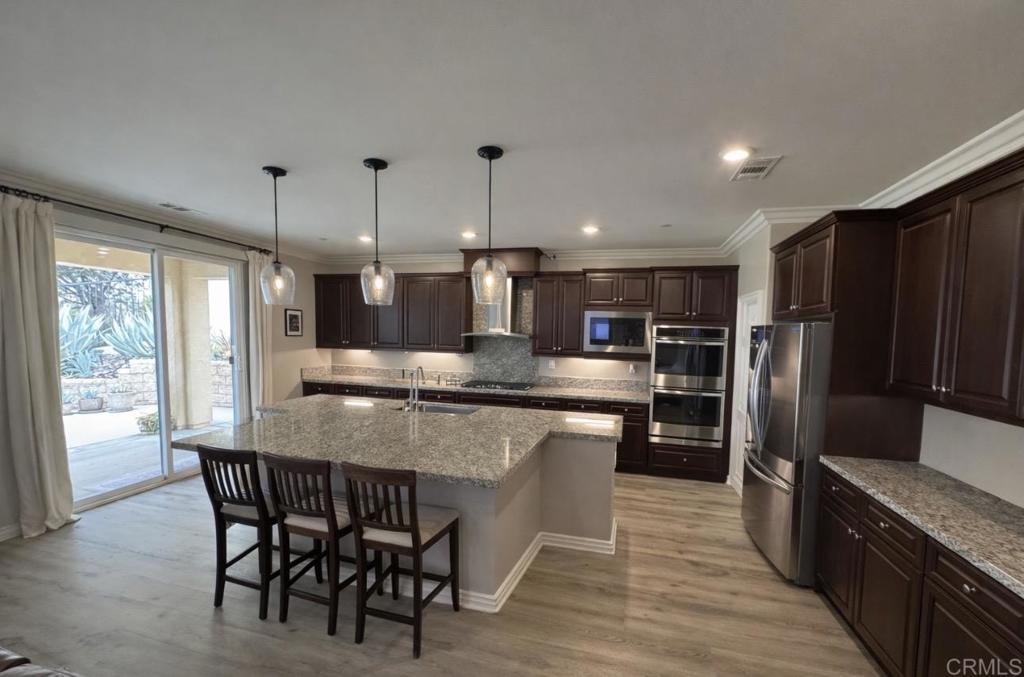 33792 Baystone Street Temecula, CA 92592 - Photo 17 of 21 a large kitchen with kitchen island a large island in the center