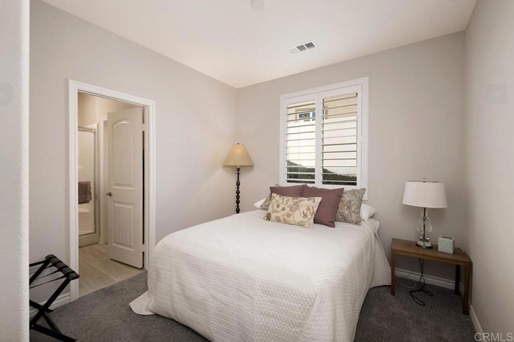 33792 Baystone Street Temecula, CA 92592 - Photo 18 of 21 a bedroom with a bed and a lamp on table