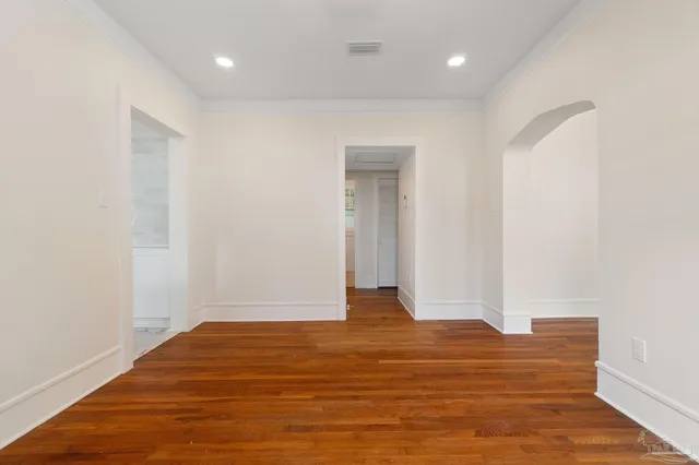 a view of an empty room with wooden floor