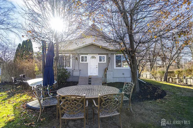 a view of a patio with table and chairs and potted plants with large tree