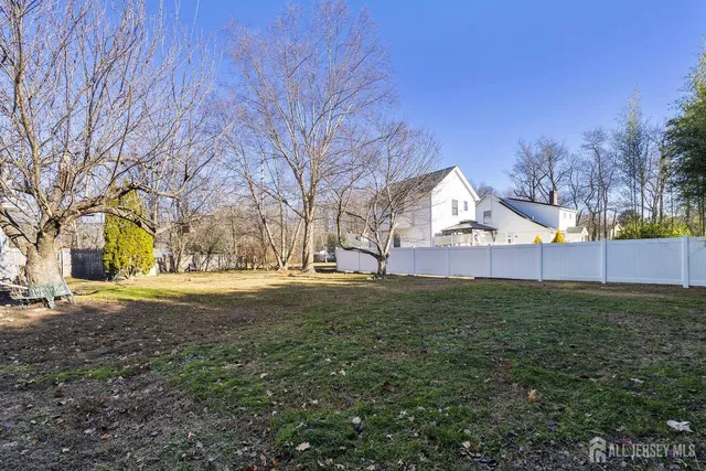 a view of yard with tree and wooden fence