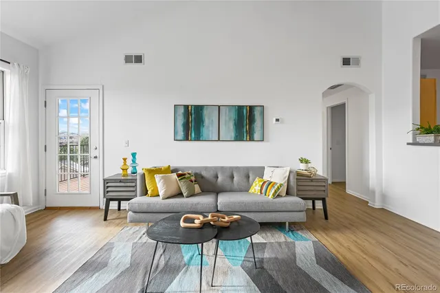 a living room with furniture and a wooden floor