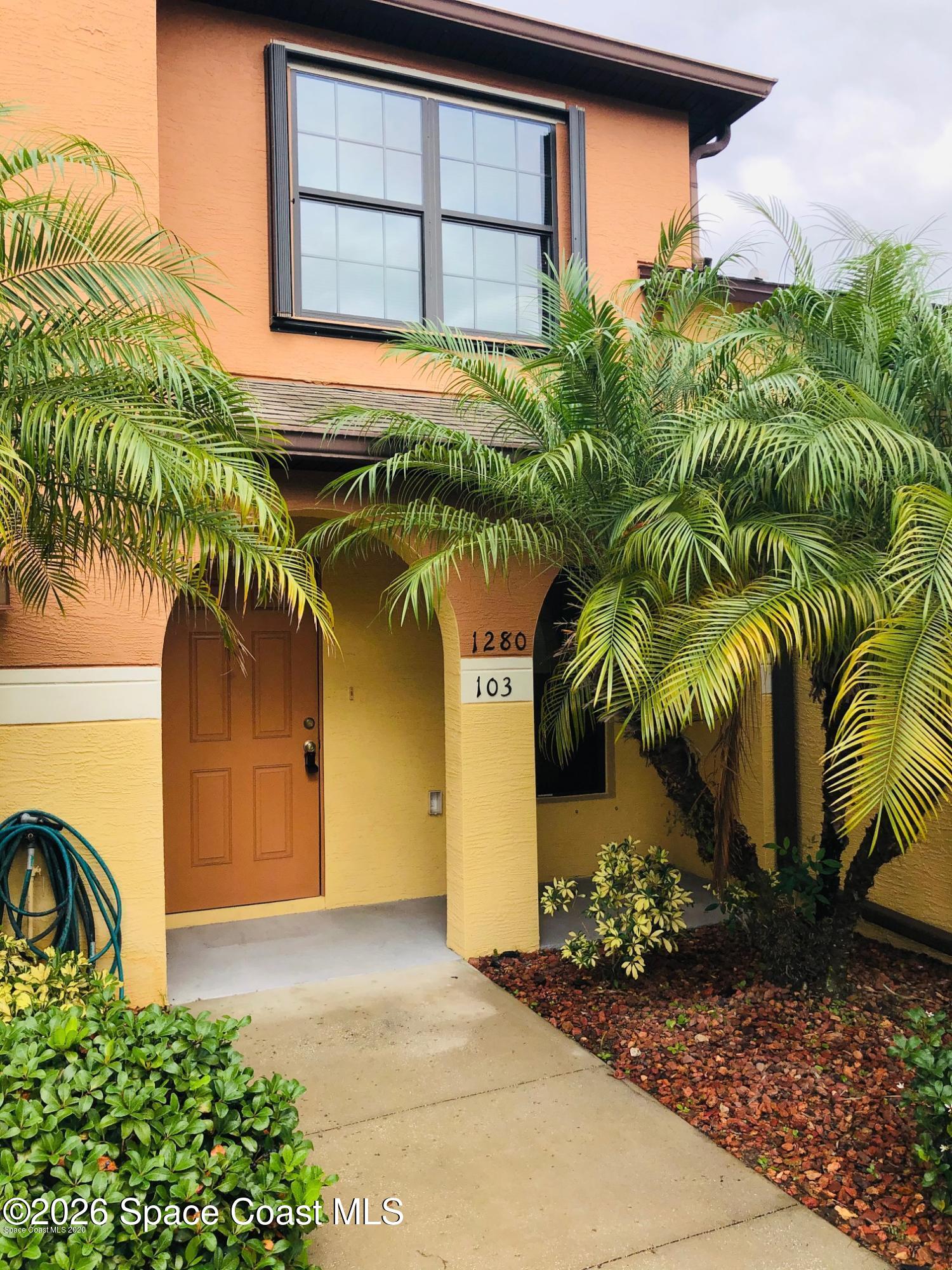 1280 Luminary Circle, Unit 103 Melbourne, FL 32901 - Photo 2 of 14 a front view of a house with garden