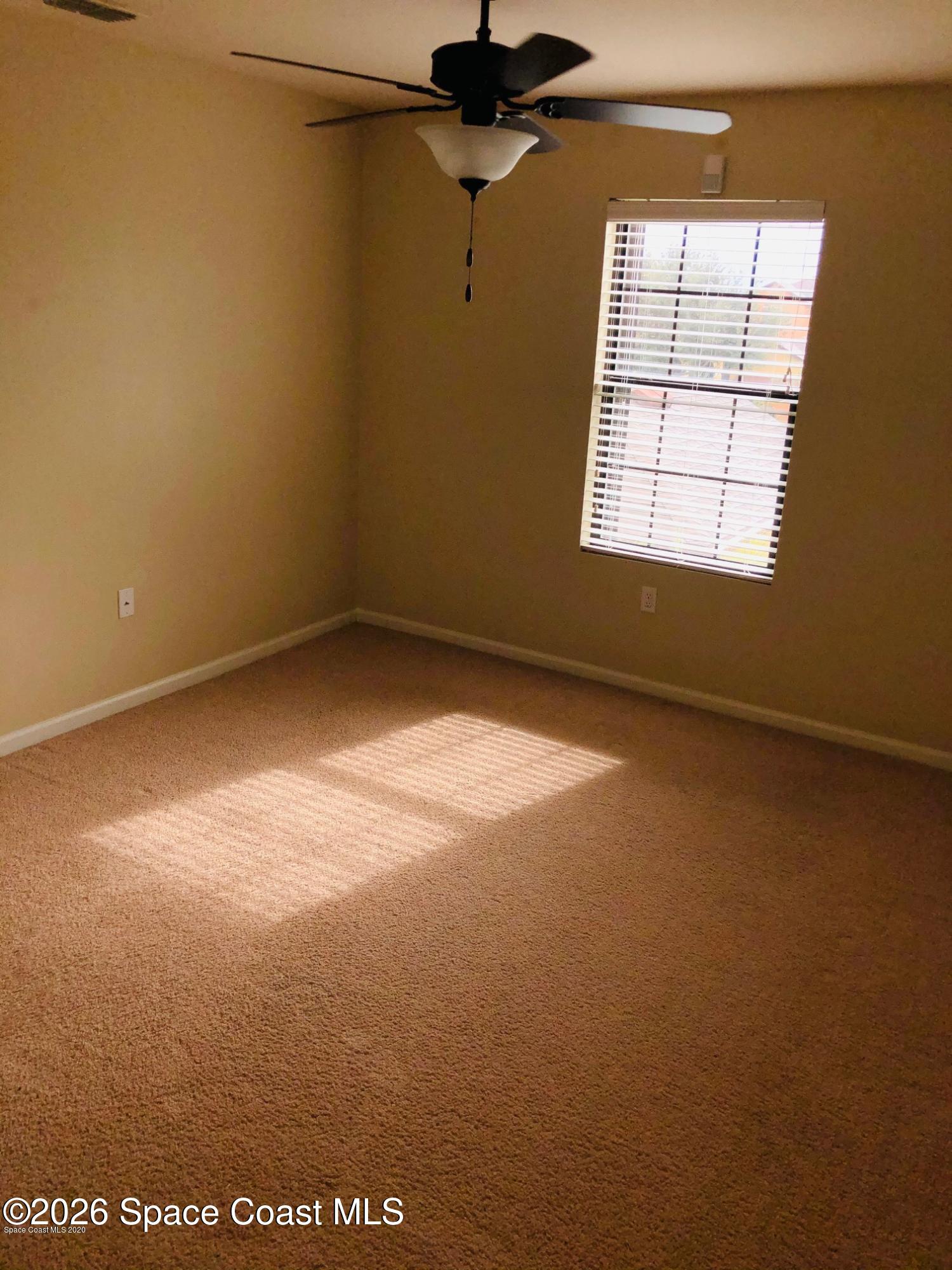 1280 Luminary Circle, Unit 103 Melbourne, FL 32901 - Photo 6 of 14 an empty room with windows and fan