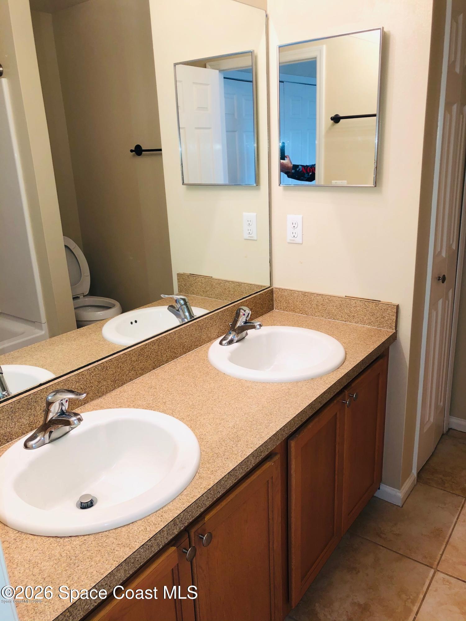 1280 Luminary Circle, Unit 103 Melbourne, FL 32901 - Photo 8 of 14 a bathroom with a sink and a mirror