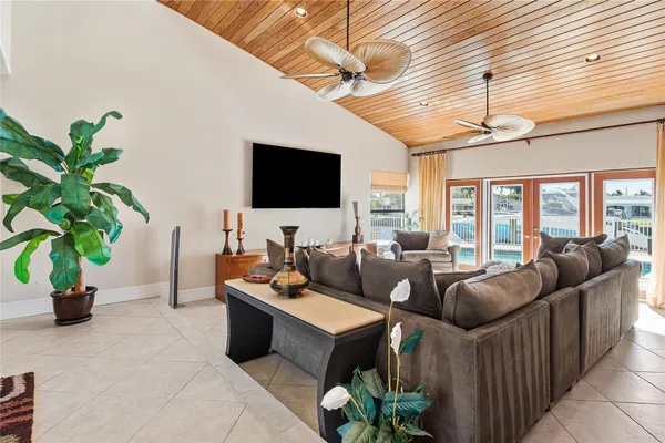 a living room with furniture a flat screen tv and a potted plant