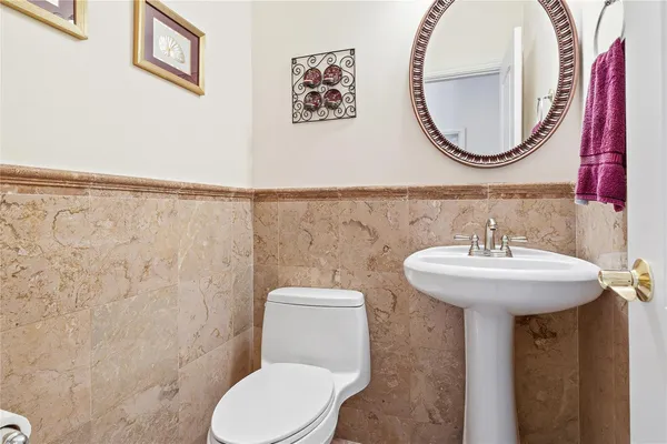 a bathroom with a toilet sink and mirror