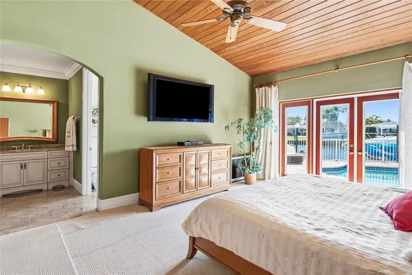 a bedroom with a large bed and a flat tv screen
