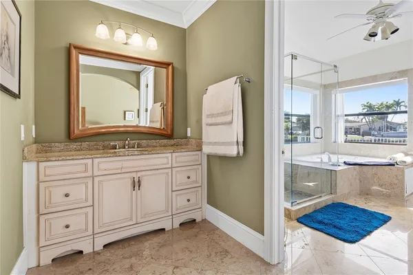 a bathroom with a granite countertop sink vanity and mirror