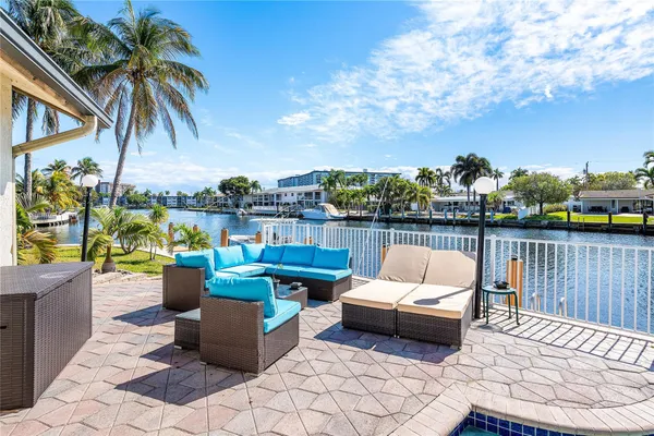 a view of a patio with couches potted plants and a palm tree