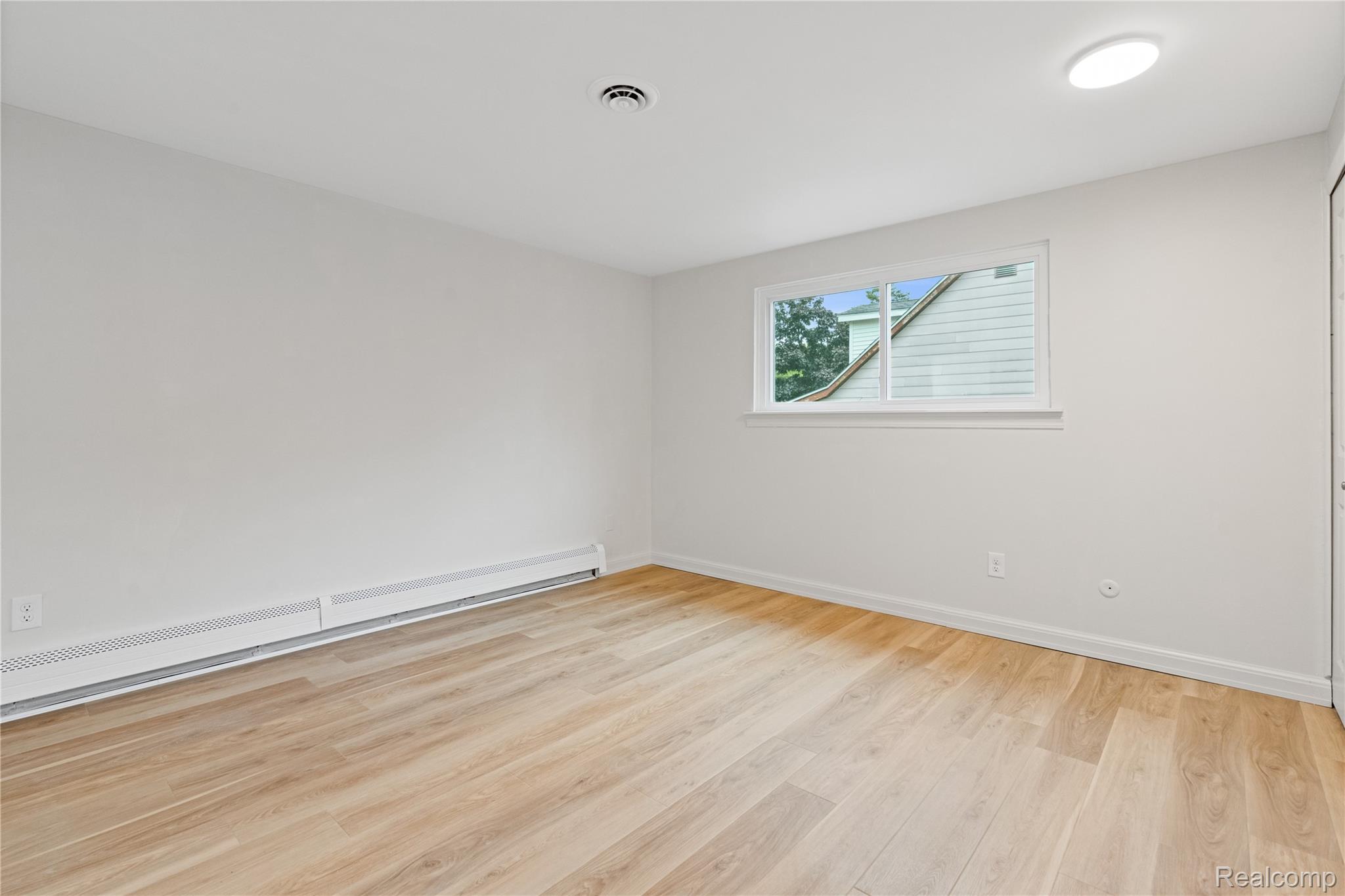8240 Hampton Road Grosse Ile, MI 48138 - Photo 18 of 33 Light wood-finish flooring with white walls and baseboard heating