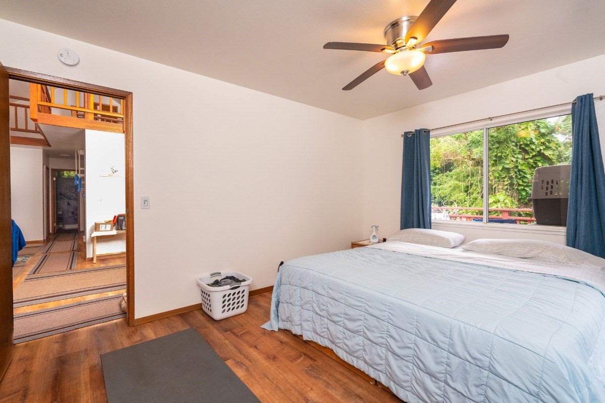 6220 Olohena Road Kapaa, HI 96746 - Photo 8 of 29 a bedroom with a bed and a chandelier